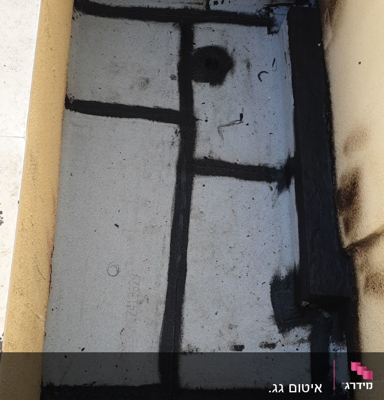 איטום גג עם חומר שחור לאורך הקווים והפינות